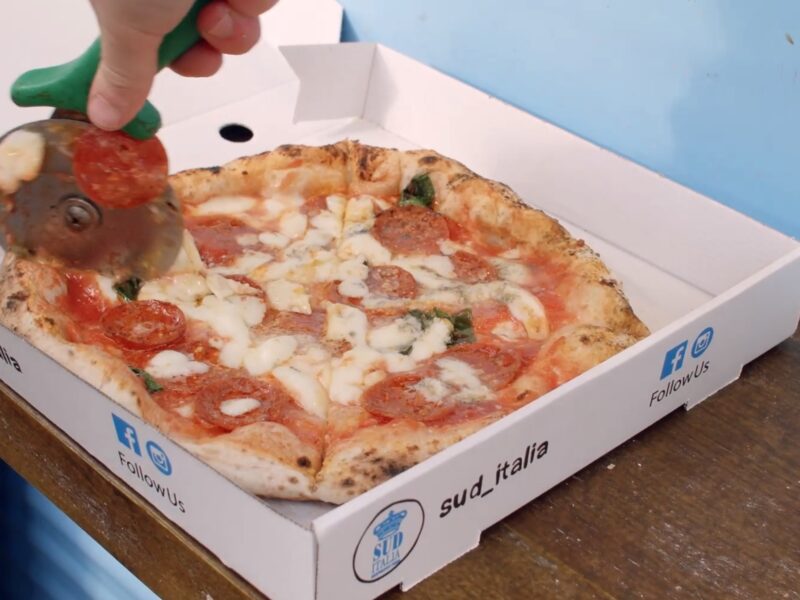 Napolitan pizza being sliced and boxed up